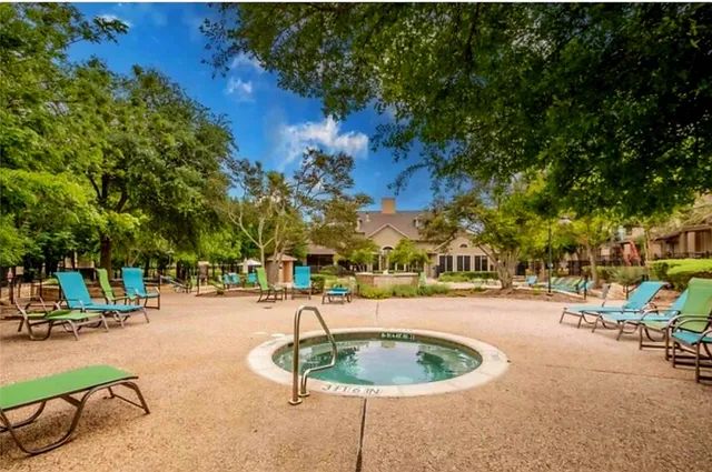 a backyard of a house with a fountain and outdoor seating