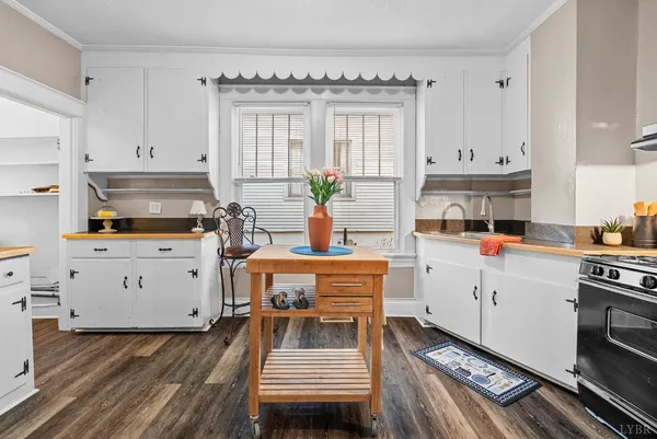 a kitchen with a white stove top oven and white cabinets
