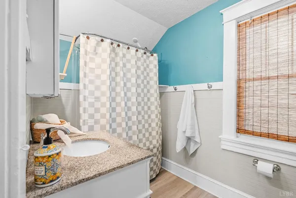a bathroom with a granite countertop sink and a mirror