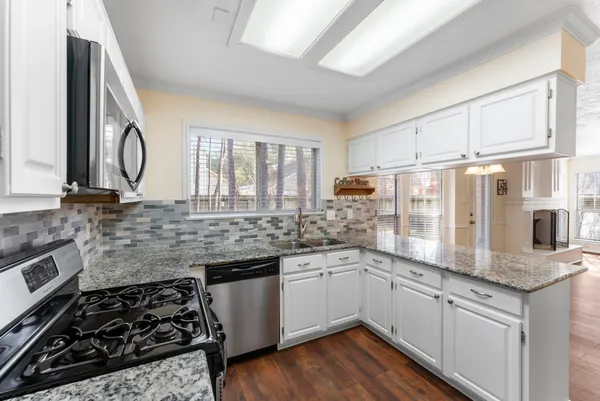 a kitchen with stainless steel appliances a sink stove and cabinets