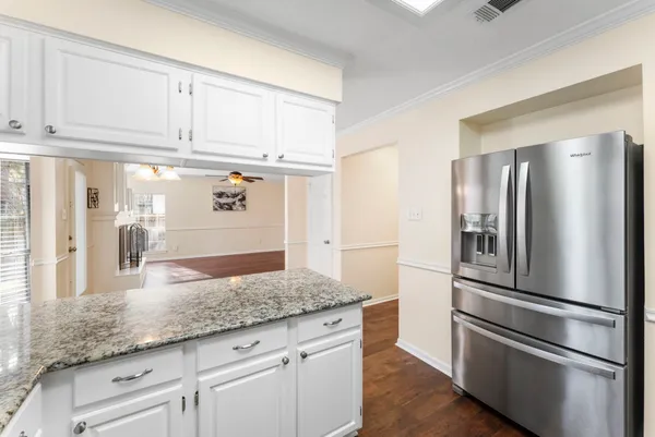 a kitchen with granite countertop stainless steel appliances a refrigerator and cabinets