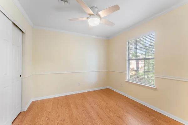 an empty room with a window and a ceiling fan