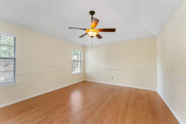 an empty room with a window and a ceiling fan