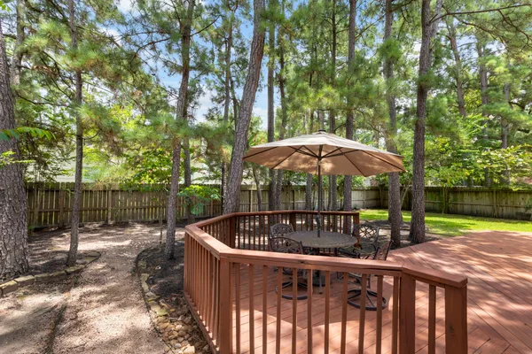 a view of backyard with table and chairs under an umbrella
