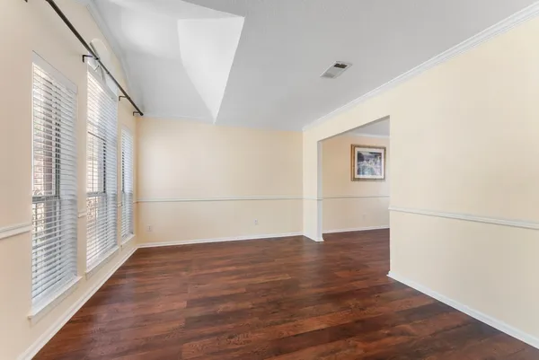 a view of a livingroom with wooden floor and a window