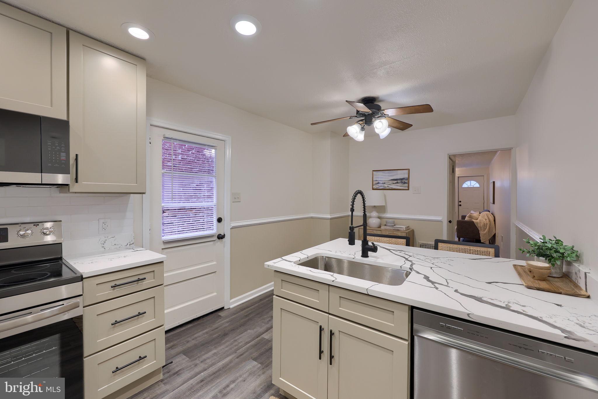 528 High Street Lancaster, PA 17603 - Photo 14 of 32 a kitchen with a sink dishwasher a stove and white cabinets with wooden floor