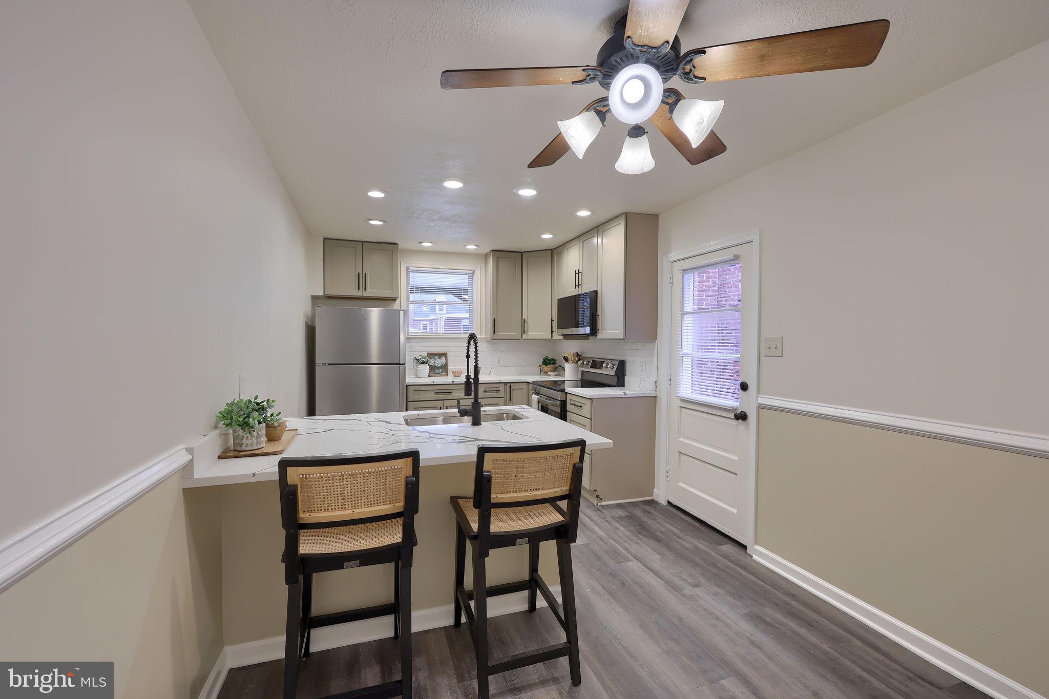 528 High Street Lancaster, PA 17603 - Photo 9 of 32 a kitchen with a dining table chairs refrigerator and cabinets