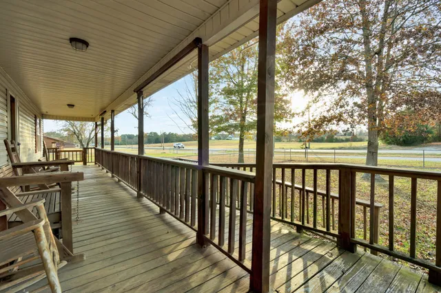 a view of a balcony with wooden floor and furniture