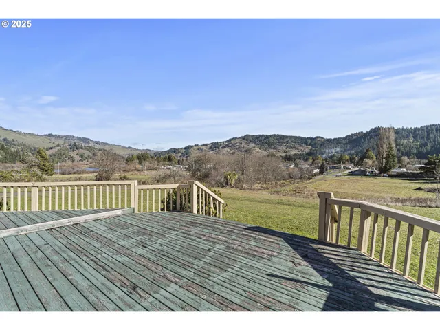a view of a wooden balcony with an outdoor space