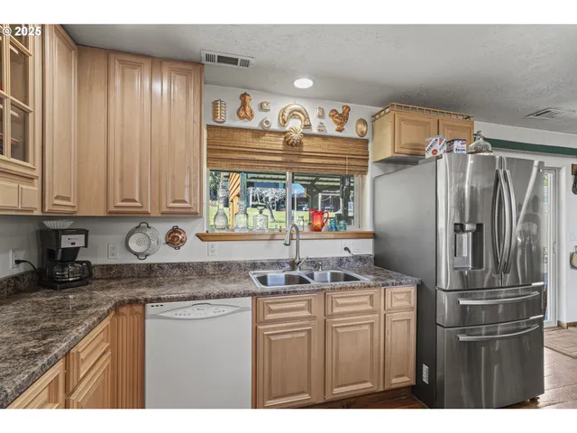 a kitchen with stainless steel appliances granite countertop a refrigerator and a sink