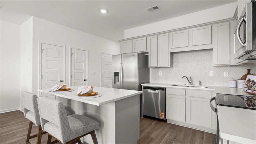 204 Kenmore Circle Perry, GA 31069 - Photo 8 of 47 a kitchen with stainless steel appliances kitchen island a table chairs sink and cabinets