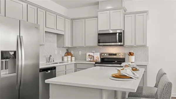 a kitchen with stainless steel appliances a stove a sink and a microwave
