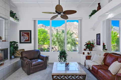 a living room with furniture ceiling fan and a window