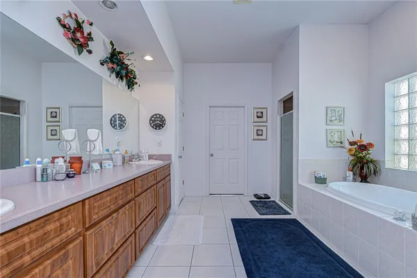 a spacious bathroom with a tub sink and mirror