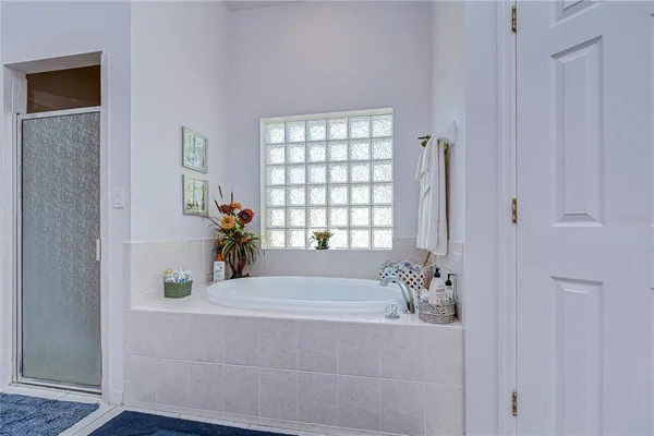 a bathroom with a tub shower and a window