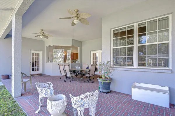 a dining room with wooden floor a chandelier a glass table and chairs