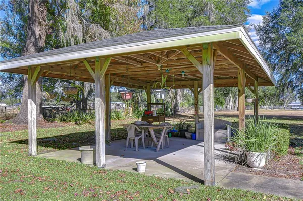 a view of a patio with table and chairs under an umbrella with a small yard