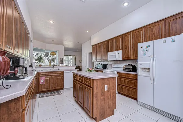a kitchen with stainless steel appliances granite countertop a stove top oven a refrigerator a sink and dishwasher