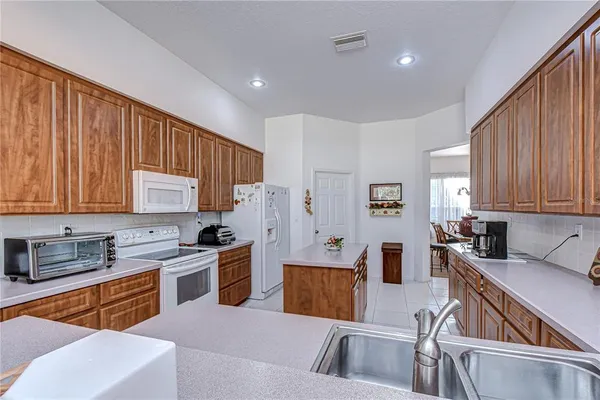 a kitchen with stainless steel appliances granite countertop a sink wooden cabinets and a refrigerator