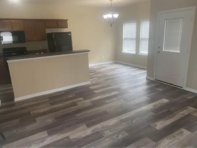 a view of a kitchen with furniture and wooden floor