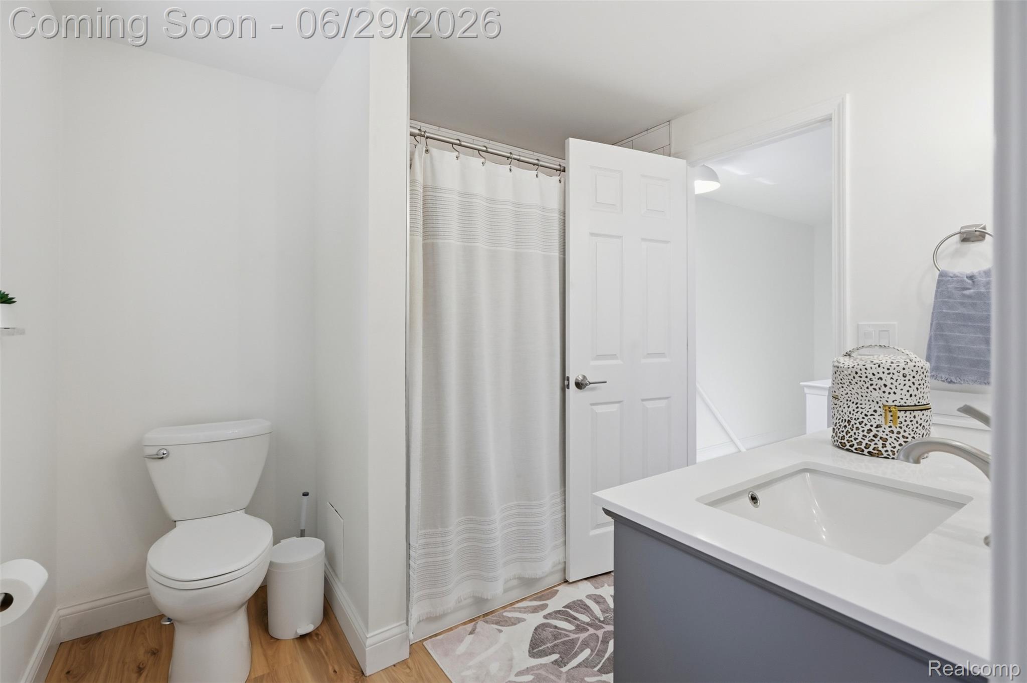 45179 Rudgate Road Canton, MI 48188 - Photo 17 of 48 Bathroom featuring a white toilet, wood-finish flooring, and a shower with a white curtain