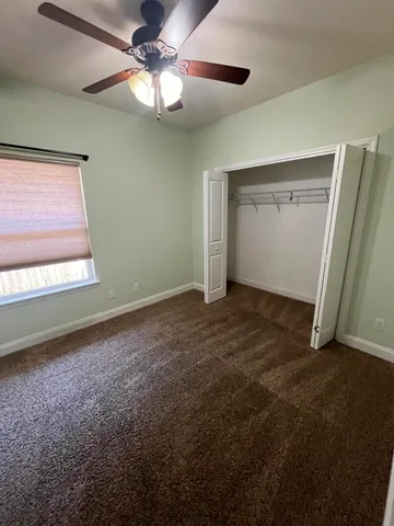 a view of empty room with a ceiling fan and window