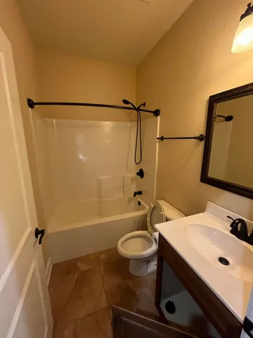 an empty room with a chandelier fan and a window