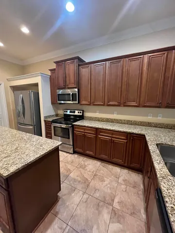 a kitchen with stainless steel appliances granite countertop a stove a sink and a microwave