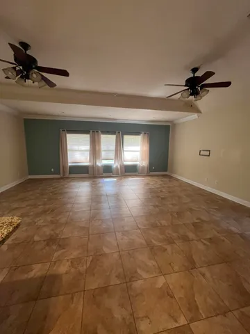 a view of a livingroom with a ceiling fan and window