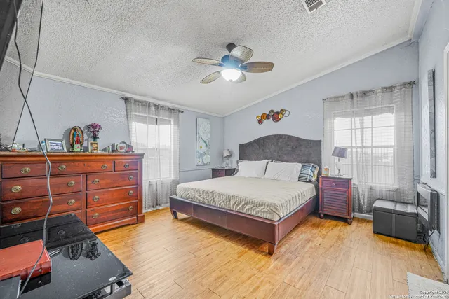 a spacious bedroom with a bed and wooden floor