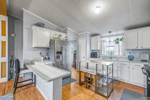 a kitchen with a table chairs refrigerator and cabinets