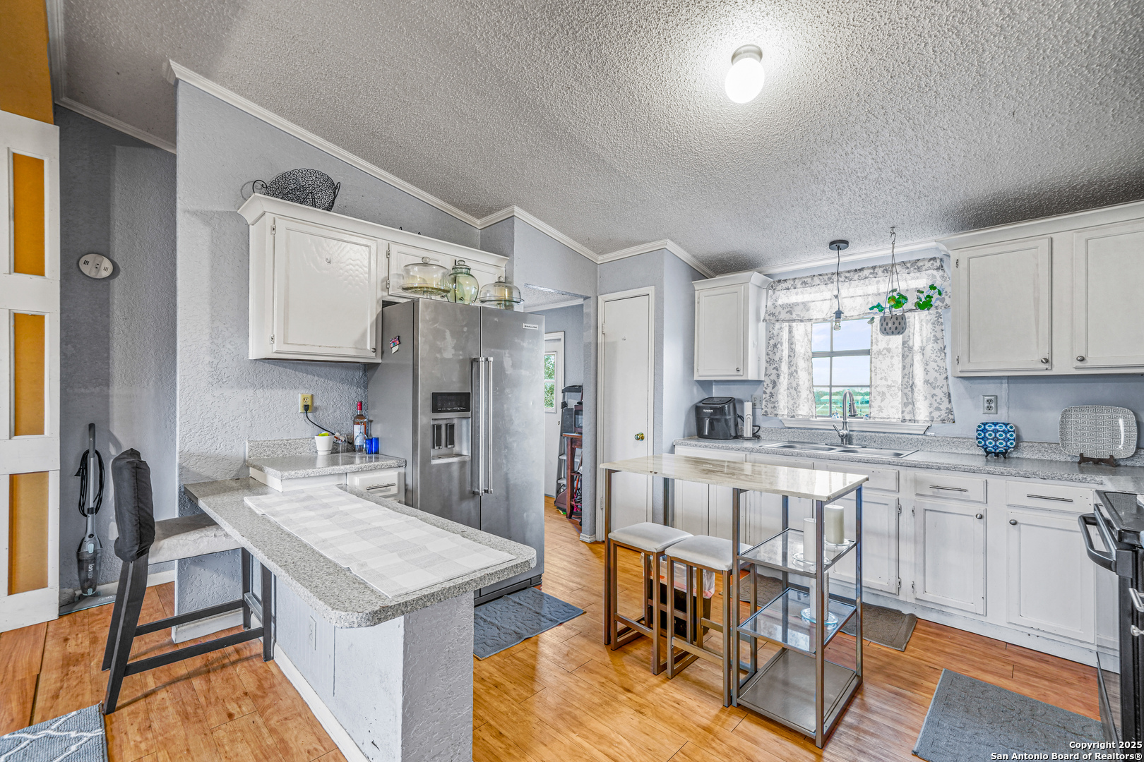 927 County Road 6846 Lytle, TX 78052 - Photo 3 of 21 a kitchen with a table chairs refrigerator and cabinets