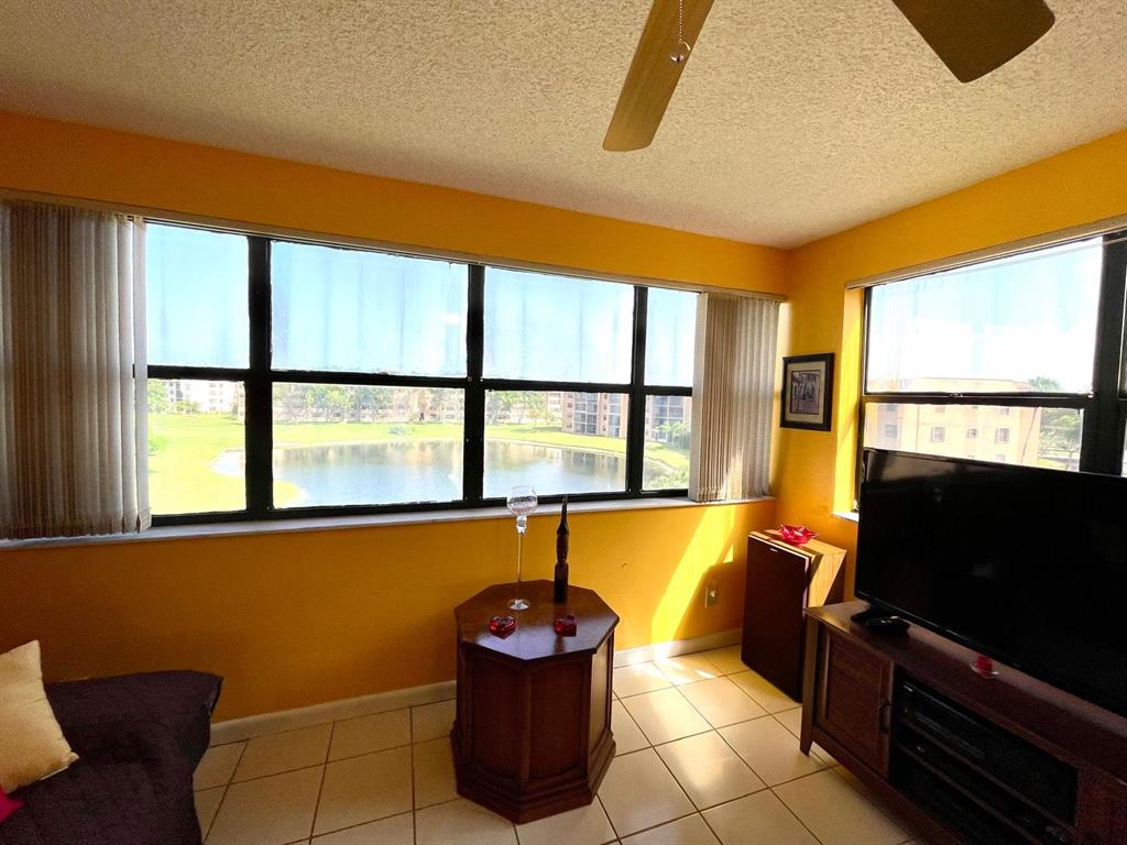 10444 Northwest 30th Court, Unit 409 Sunrise, FL 33322 - Photo 17 of 28 a living room with a flat screen tv and windows