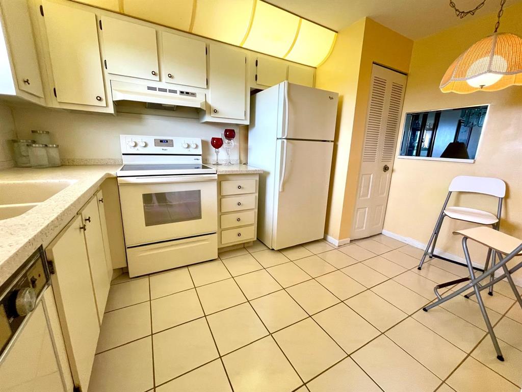 10444 Northwest 30th Court, Unit 409 Sunrise, FL 33322 - Photo 5 of 28 a kitchen with a refrigerator a stove a sink and cabinets