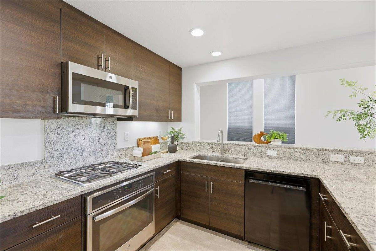 1989 Trento Loop Milpitas, CA 95035 - Photo 7 of 32 a kitchen with stainless steel appliances granite countertop a sink stove and microwave