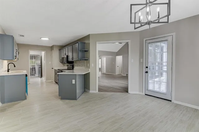 a large kitchen with kitchen island a sink stainless steel appliances and cabinets