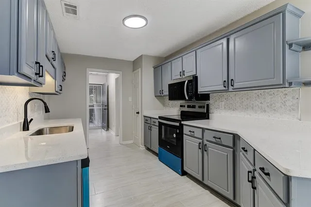 a kitchen with stainless steel appliances granite countertop a sink and a stove