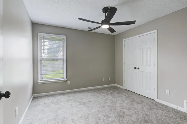 a bedroom with a large bed and a window