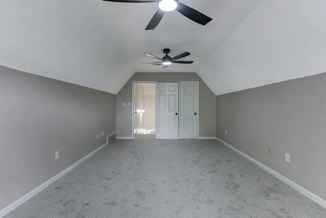 an empty room with a window and a ceiling fan