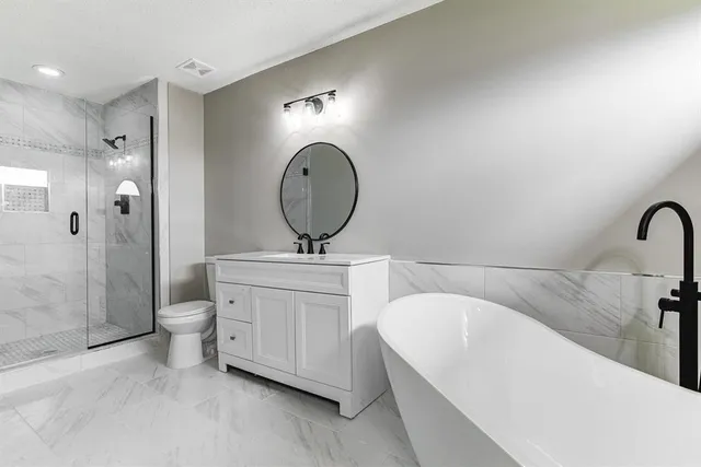a bathroom with a double vanity sink mirror and bathtub