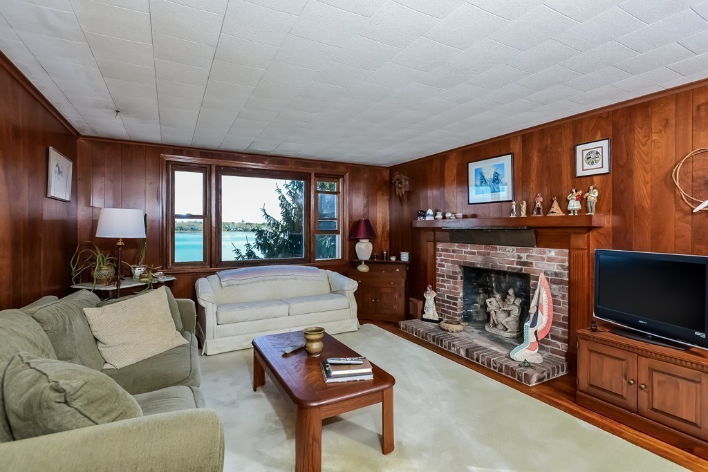 51 Pine Ridge Road Bourne, MA 02532 - Photo 13 of 25 a living room with furniture a flat screen tv and a fireplace