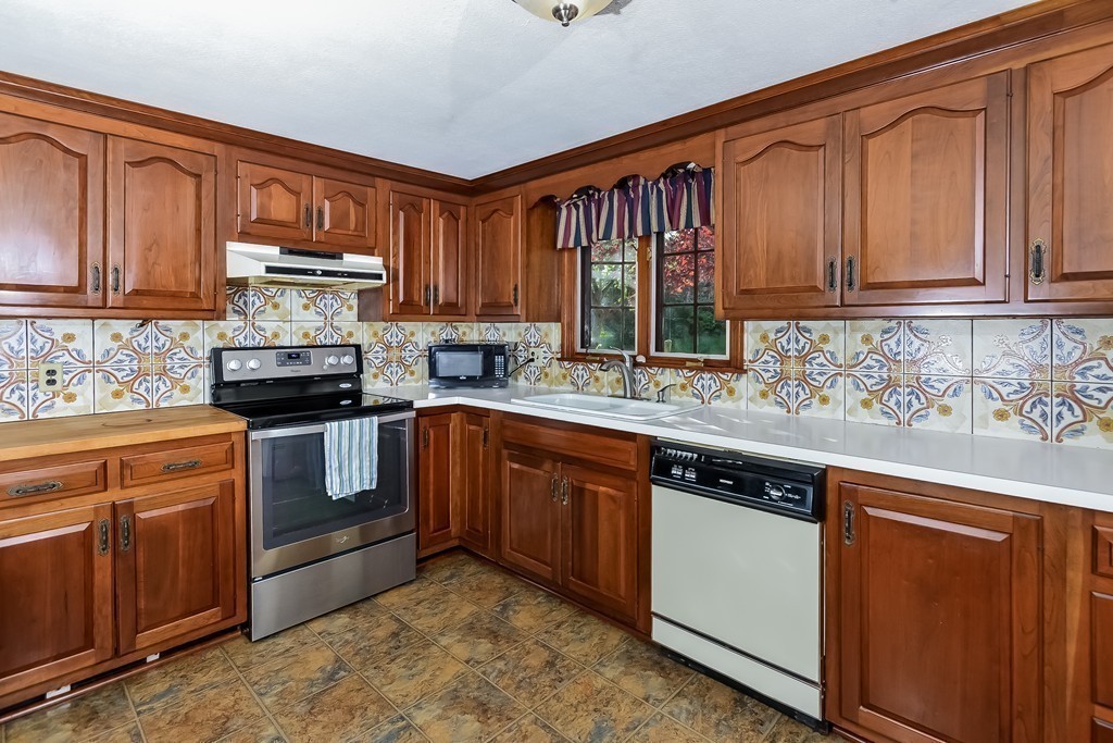 51 Pine Ridge Road Bourne, MA 02532 - Photo 10 of 25 a kitchen with stainless steel appliances granite countertop a stove sink microwave and cabinets