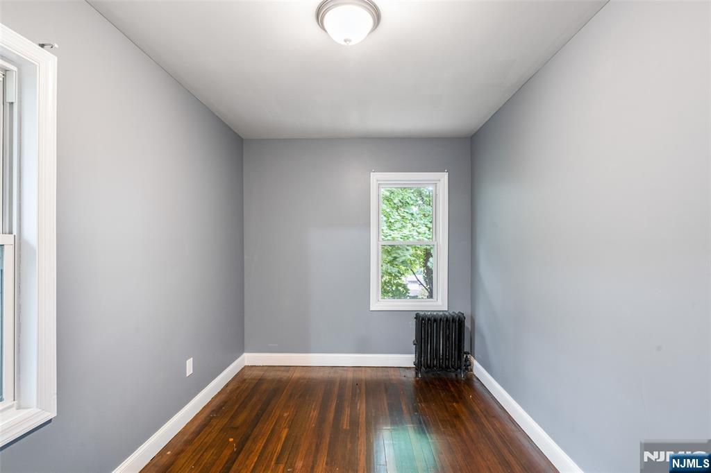 402 Morse Avenue, Unit 2 Ridgefield, NJ 07657 - Photo 6 of 8 a view of an empty room with wooden floor and a window