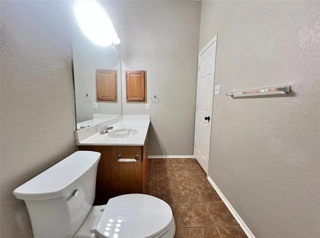 a bathroom with a sink a toilet a mirror and vanity