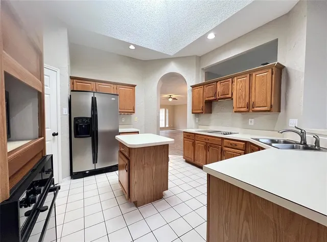 a kitchen with stainless steel appliances a sink cabinets and wooden floor