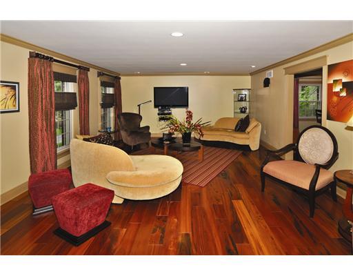 Living Room. Living Room offers Brazilian "Tiger Wood" flooring (throughout the first floor), Recessed lighting, custom made crown molding and door casings (also throughout the home), and triple floor to ceiling windows.