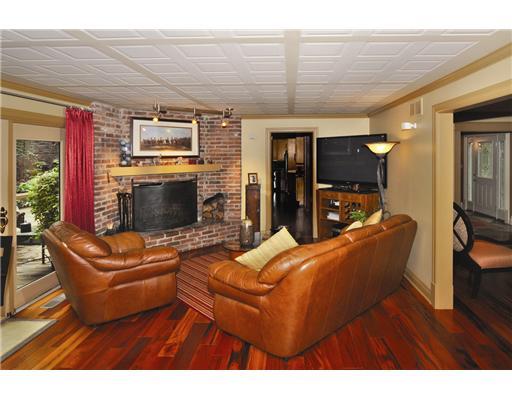 Family Room. Custom ceiling gives texture and warmth to the Family Room with detailed lighting, log burning fireplace, and large French doors to deck and yard.