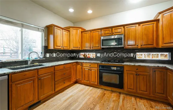 a kitchen with granite countertop stainless steel appliances and wooden cabinets