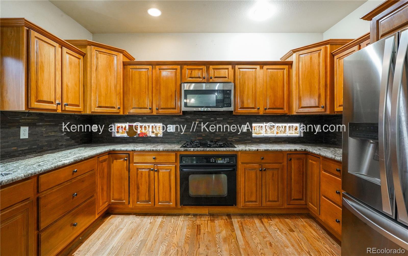 15879 Agate Creek Drive Monument, CO 80132 - Photo 5 of 24 a kitchen with granite countertop stainless steel appliances and wooden cabinets