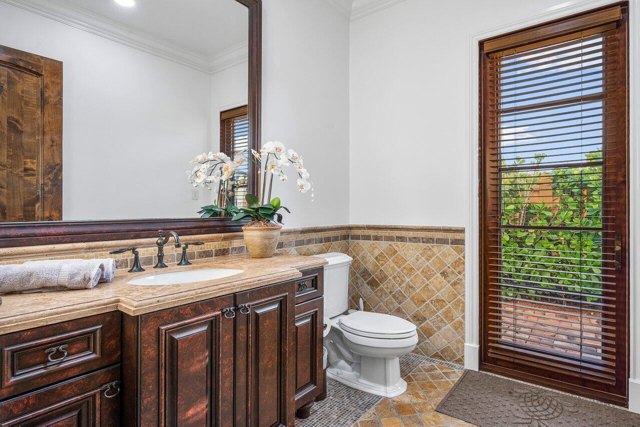 591 Phillips Drive Boca Raton, FL 33432 - Photo 28 of 90 a bathroom with a granite countertop toilet a sink a mirror and a window